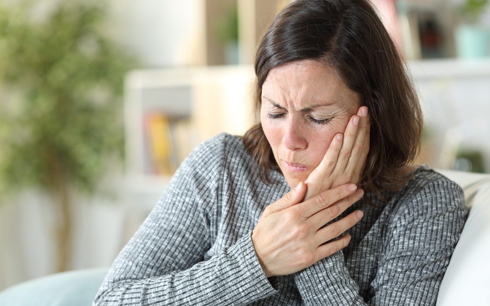 Woman holding face in pain