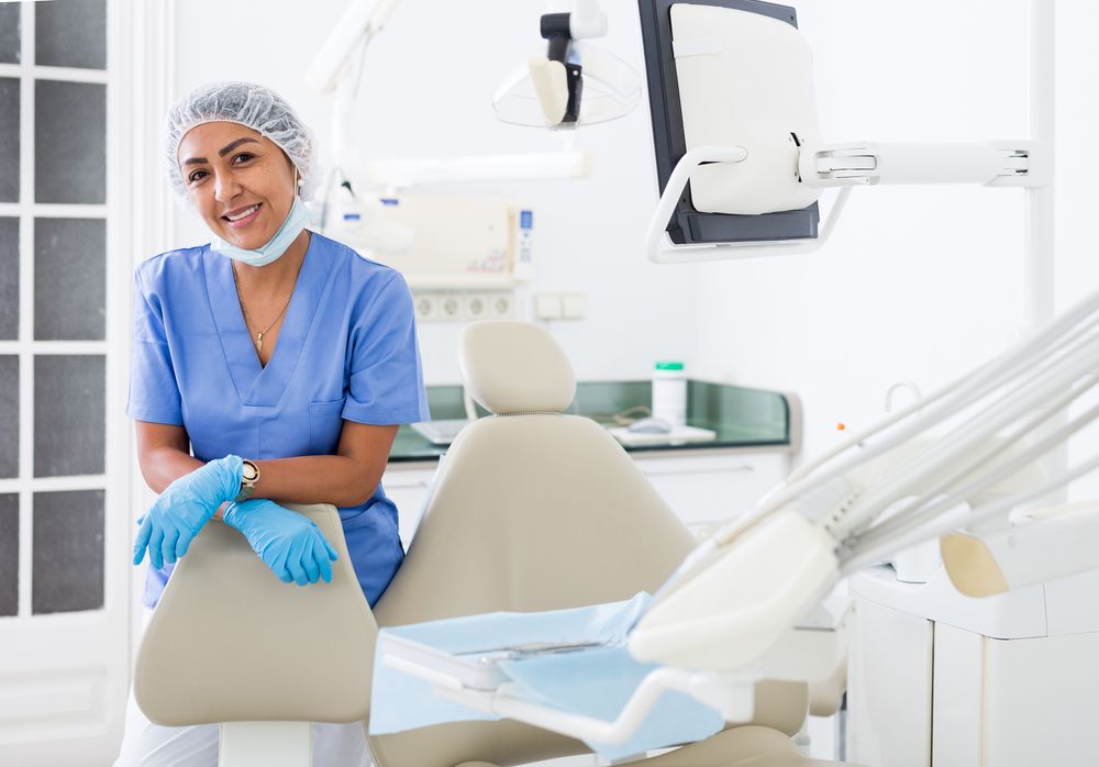 dentist with surgical hat next to dental chair