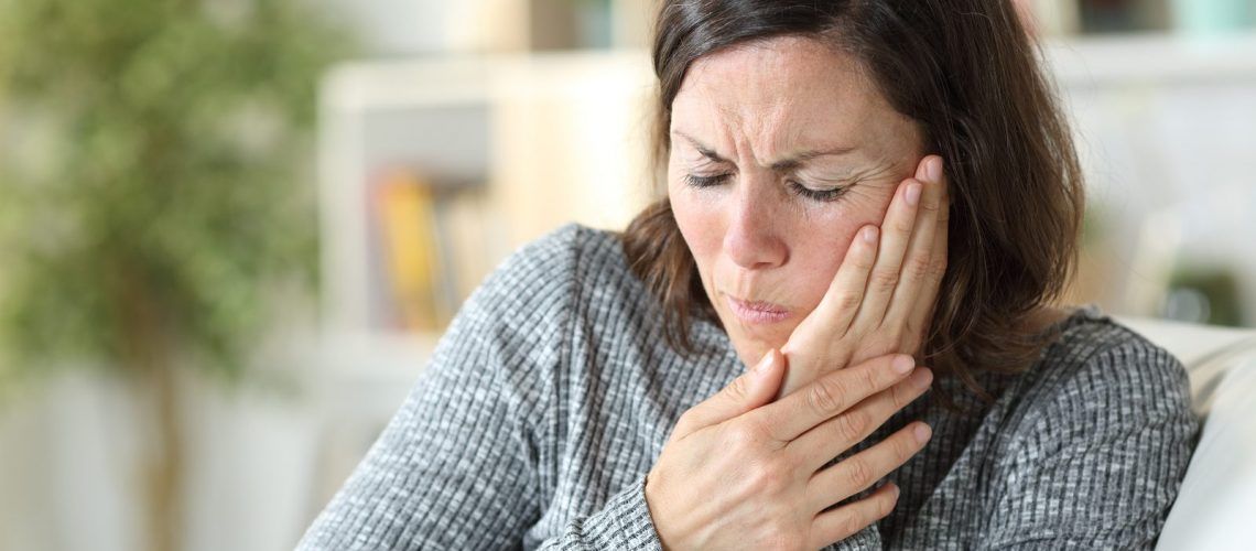 Woman holding face in pain